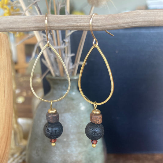 Yogis choice. Brass drop earrings, featuring lava stone and garnet bead, with gold plated hook.